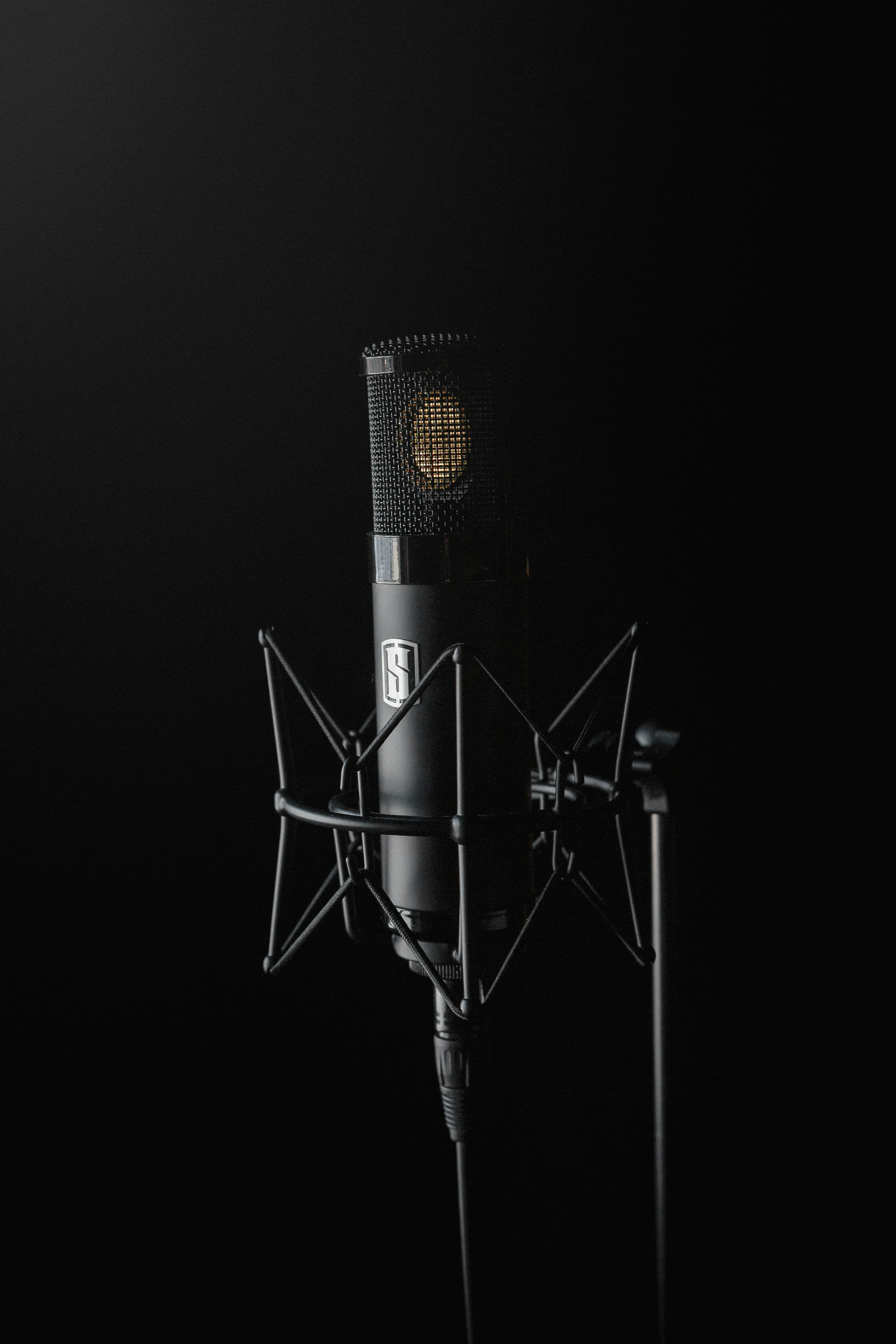 Black condenser microphone against a black background